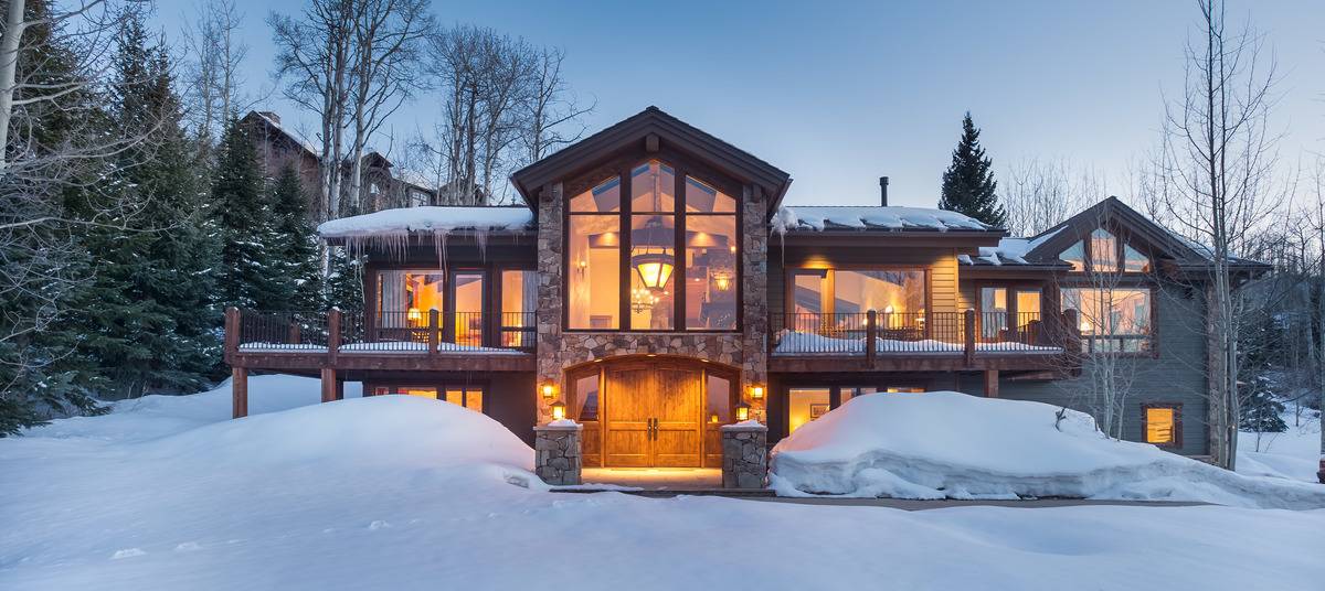 Lit up house in the mountains covered in snow